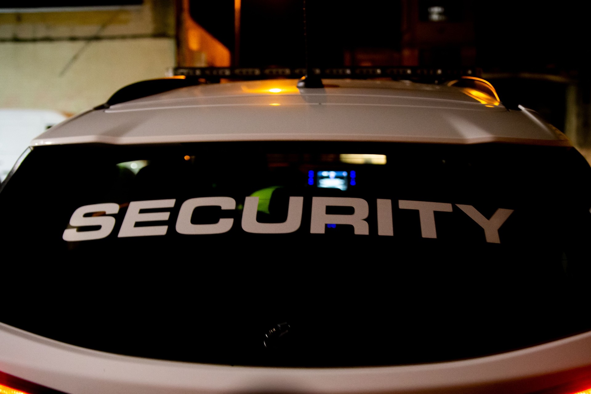 Security guard is driving a patrol car at night city